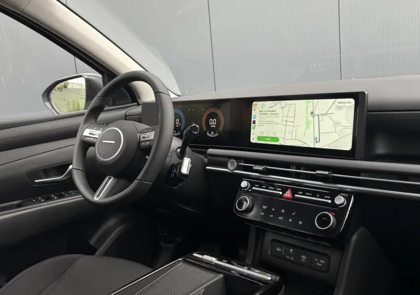 Vue intérieure côté conducteur du Hyundai Tucson 2026, tableau de bord moderne avec écran tactile large et volant multifonction.