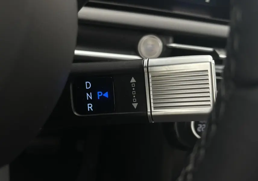 Gros plan sur la commande de boîte automatique avec affichage digital D, N, R, P dans un Hyundai Tucson blanc Atlas 2026.