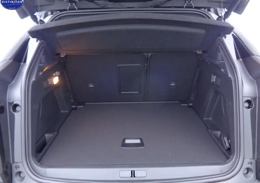 Coffre ouvert d'un Peugeot 3008 noir métal 2023, montrant un espace de chargement spacieux et bien éclairé.