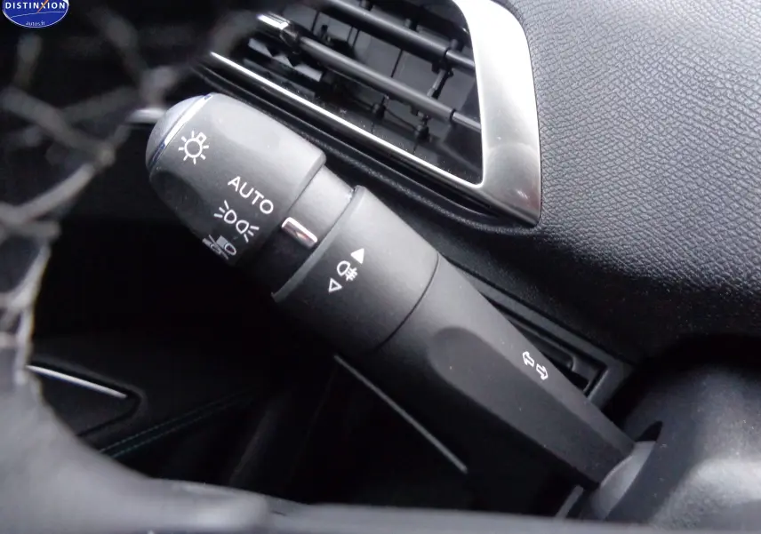 Gros plan sur la commande des phares et clignotants dans l’habitacle noir du Peugeot 3008 2023 finition Allure Pack.