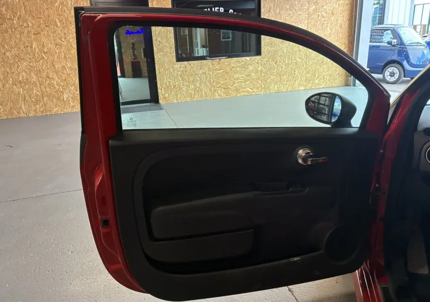 Vue intérieure de la porte avant gauche rouge de l'Abarth 500 595 Competizione 2016 avec poignée chromée.