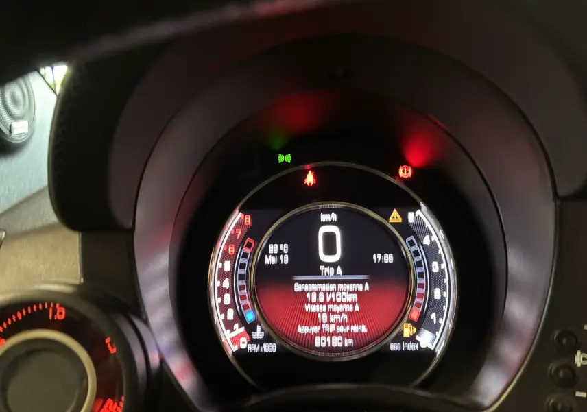 Tableau de bord numérique de l'Abarth 500 rouge 2016, affichant la vitesse à 0 km/h et divers voyants allumés.