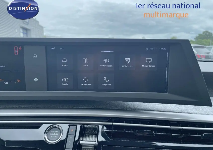Vue rapprochée de la console centrale et de l'écran tactile du Peugeot 5008 gris Artense Hybrid 2025, affichant les options multimédia et climatisation.