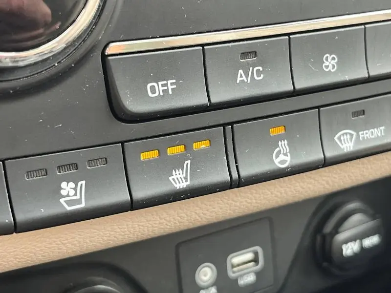 Gros plan sur les commandes de ventilation et sièges chauffants du Hyundai Tucson 2017 avec éclairage orange actif.