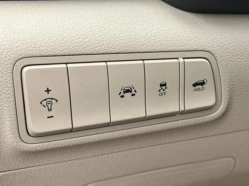 Panneau de commandes intérieures beiges du Hyundai Tucson 2017 avec boutons d'éclairage, assistance et maintien au freinage.
