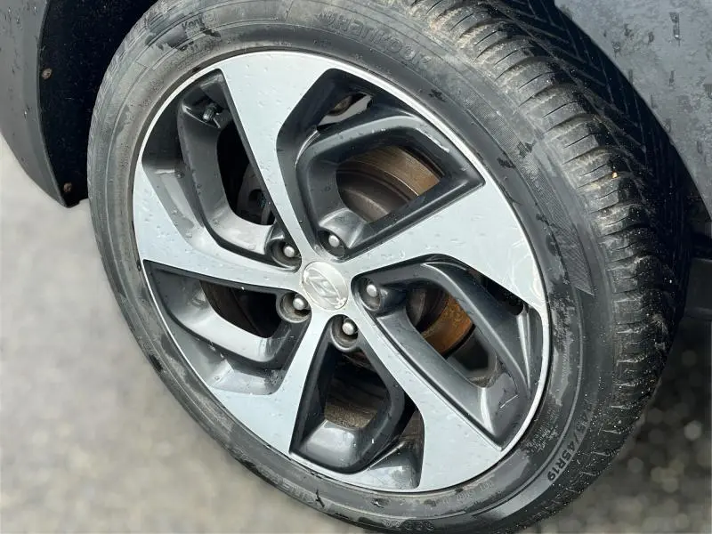 Gros plan sur la jante alliage bicolore du côté avant droit d'un Hyundai Tucson 2017 White Sand avec pneu humide