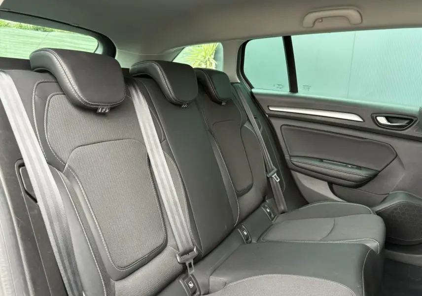 Vue latérale droite de la banquette arrière en tissu noir avec appuie-têtes et ceintures dans une Renault Mégane Break 2024.
