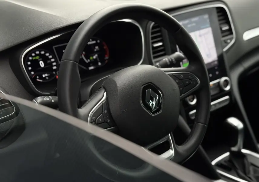 Intérieur de la Renault Mégane Break 2024, vue du volant et console centrale avec écran tactile GPS EasyLink.