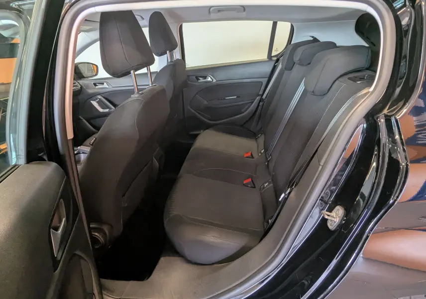 Vue intérieure côté droit montrant la banquette arrière noire et les sièges avant d'une Peugeot 308 1.2 PureTech 110 Style de 2017.