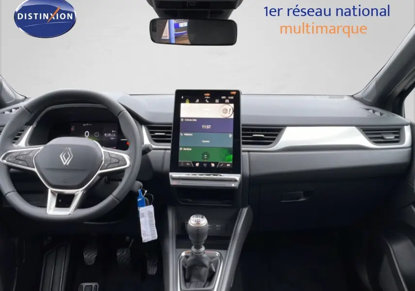 Vue intérieure frontale du tableau de bord du Renault Captur 2025 avec écran tactile vertical et volant multifonction noir.