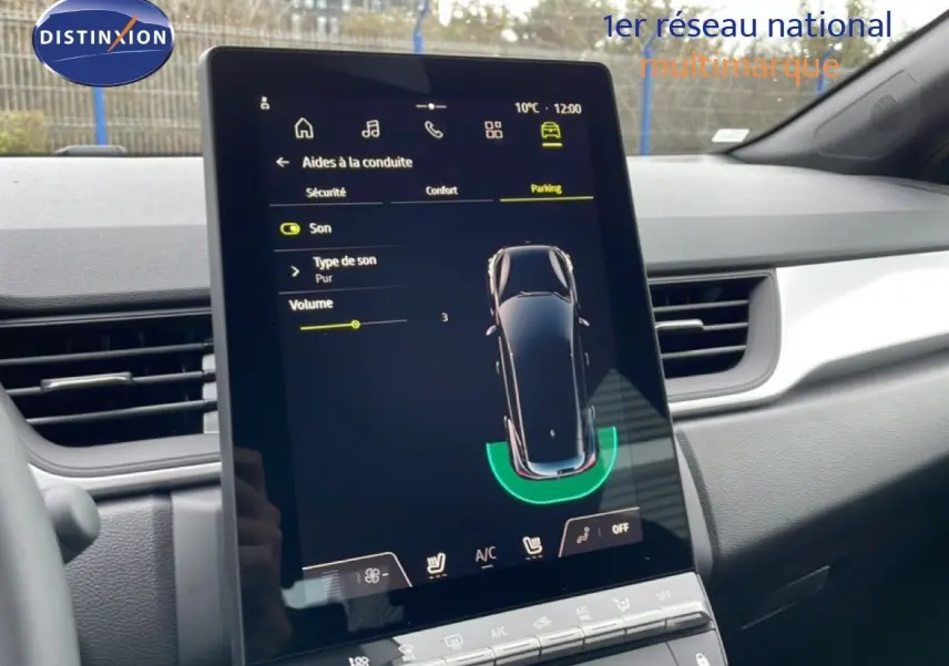 Vue intérieure centrée sur l'écran tactile du tableau de bord du Renault Captur noir étoile métal, affichant l'aide au stationnement.