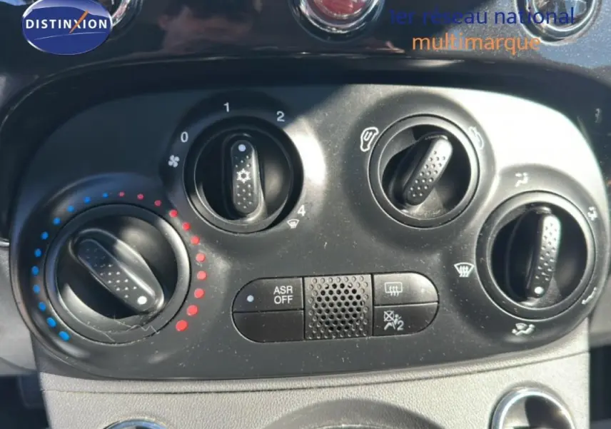Gros plan sur la console de climatisation noire de la Fiat 500 noire, avec boutons de réglage et symbole ASR OFF.