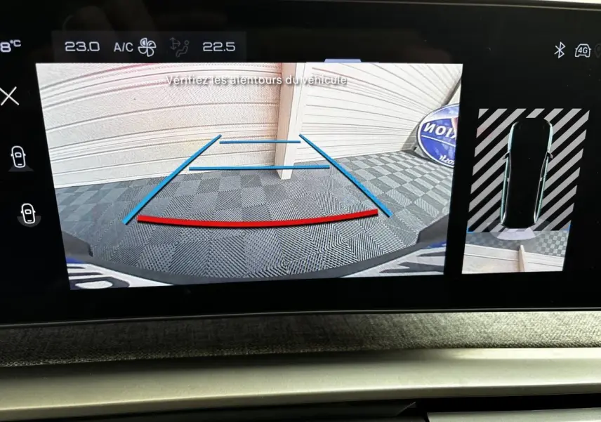 Affichage écran tactile intérieur montrant la caméra de recul et vue 360° du Peugeot 5008 gris clair 2025 en stationnement.