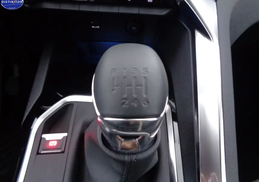Le levier de vitesse manuel noir du Peugeot 3008 2023, vue rapprochée sur la console centrale chromée.