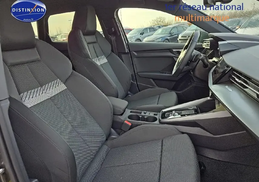 Intérieur Audi A3 Sportback 45 TFSI e 2024 vu côté conducteur, sièges sport noirs avec motifs gris et console centrale moderne.