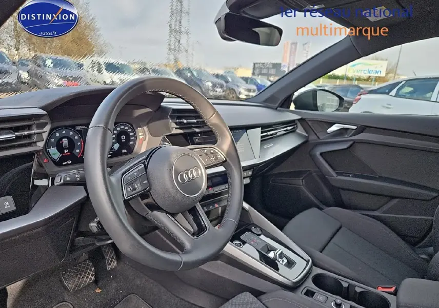 Vue intérieure côté conducteur de l'Audi A3 Sportback 45 TFSI e 2024 avec volant cuir et tableau de bord digital.
