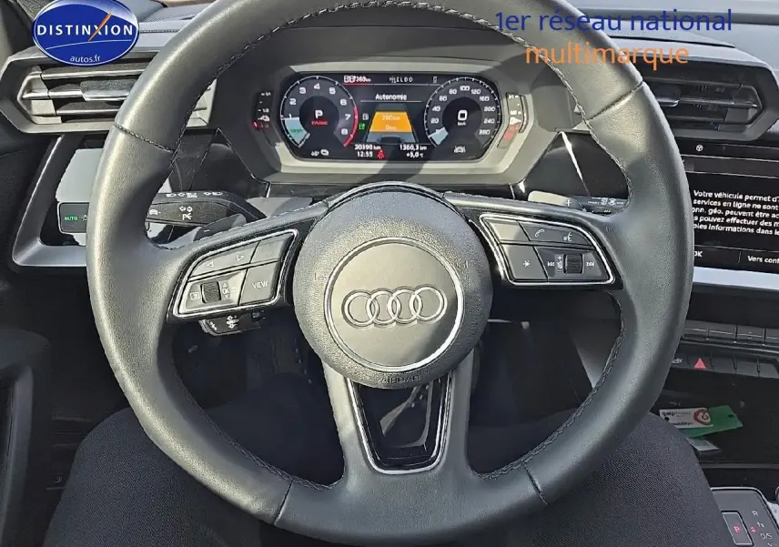 Vue centrée sur le volant cuir multifonction de l'Audi A3 Sportback 45 TFSI e gris Daytona avec tableau de bord digital.
