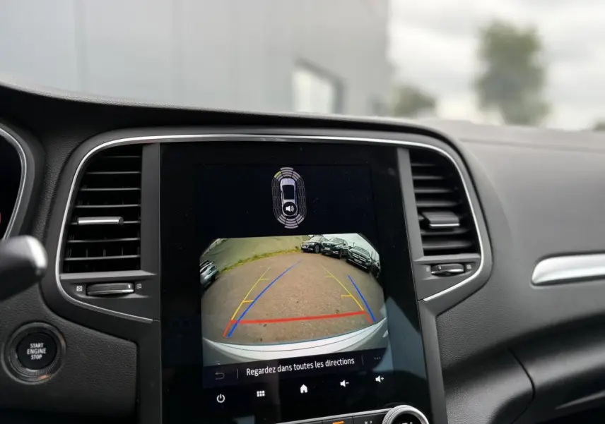 Écran tactile central affichant la caméra de recul et l'aide au stationnement du Renault Mégane Break gris Highland 2024.