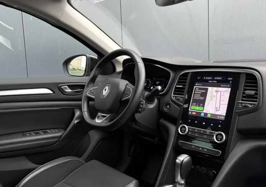 Intérieur avant gauche de Renault Mégane Break 2024 avec tableau de bord numérique et écran tactile GPS EasyLink.