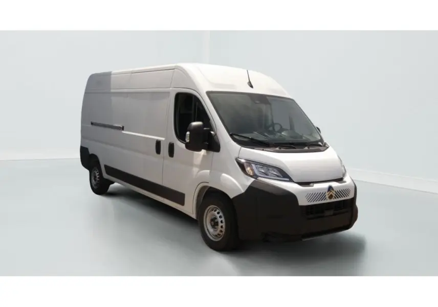 Vue 3/4 avant d’un utilitaire Citroën Jumper blanc, avec porte latérale coulissante côté droit et pare-chocs noir.