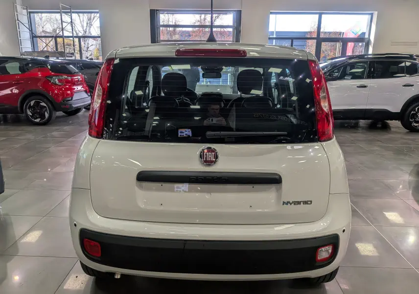 Vue arrière d'une FIAT Panda 1.0 70 CH Hybrid City blanche Gelato, avec logo et badge Hybrid visibles en concession.