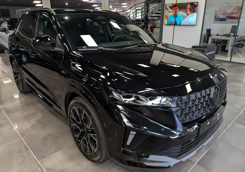 Renault Austral full hybrid noir en 3/4 avant droit, avec calandre texturée et jantes noires distinctives.