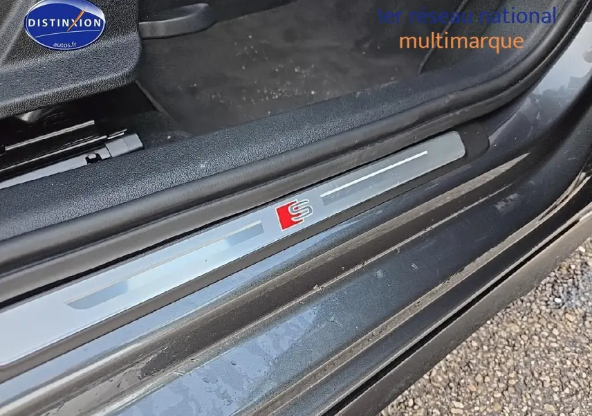 Gros plan sur la baguette de seuil de porte avec logo S sur Audi A3 Sportback gris Daytona côté gauche.