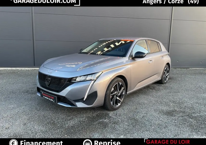 PEUGEOT 308 gris foncé en 3/4 avant droit, avec phares LED et jantes alliage noires distinctives.