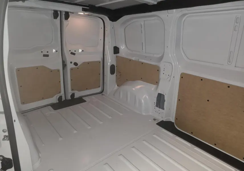 Vue intérieure arrière du fourgon blanc Opel Vivaro 2025, montrant l'espace de chargement avec panneaux de protection en bois.