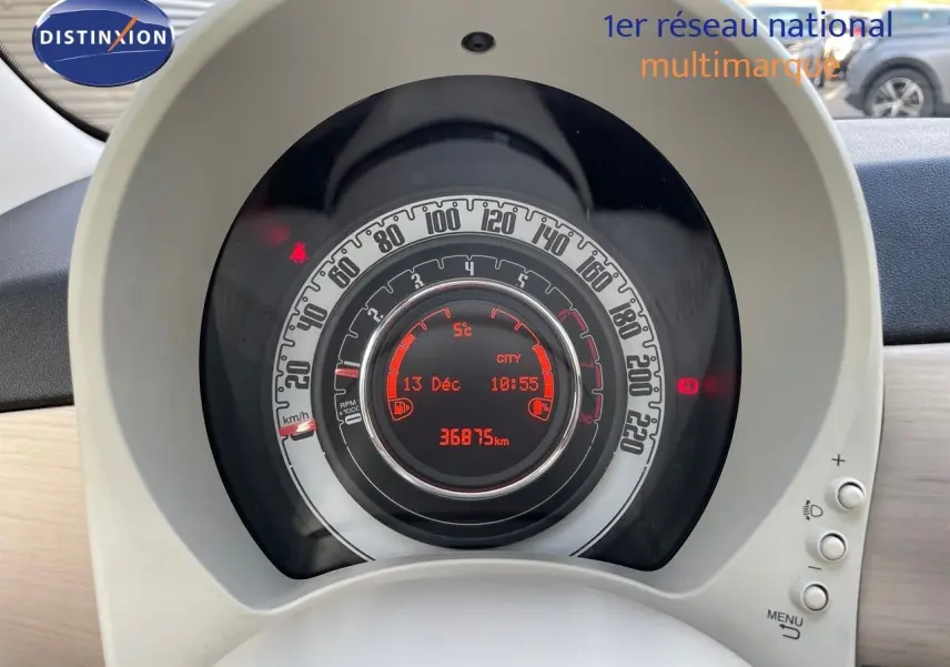 Vue rapprochée du tableau de bord de la Fiat 500 blanche, affichant le compteur digital et la vitesse en km/h.