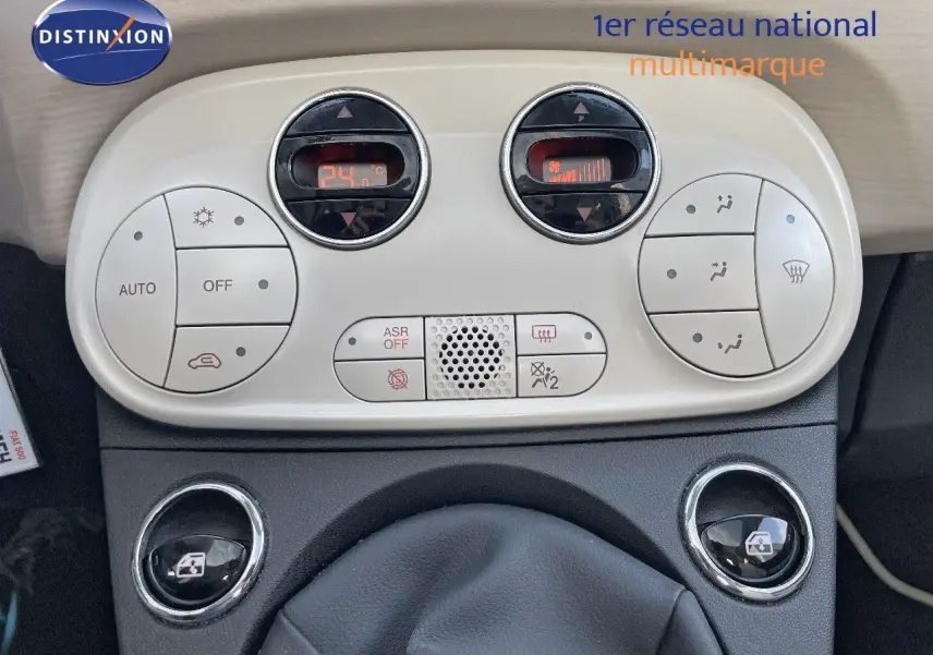 Tableau de bord de Fiat 500 blanc, vue rapprochée sur la console centrale avec commandes climatisation digitales.