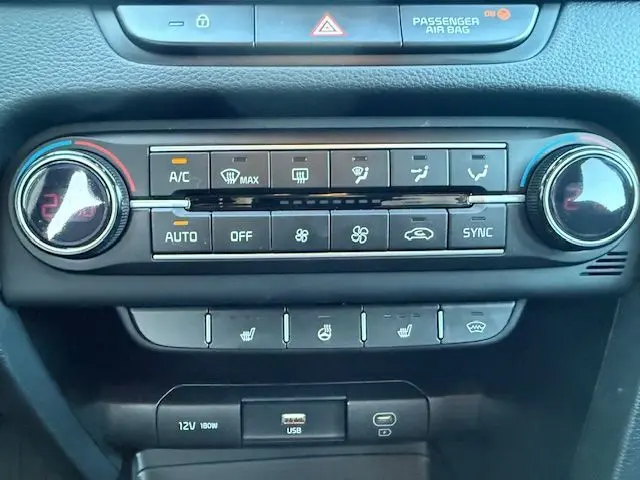 Tableau de bord de la Kia CEE'D 1.5 T-GDI 2024 montrant la console de climatisation avec commandes digitales et boutons chauffants.