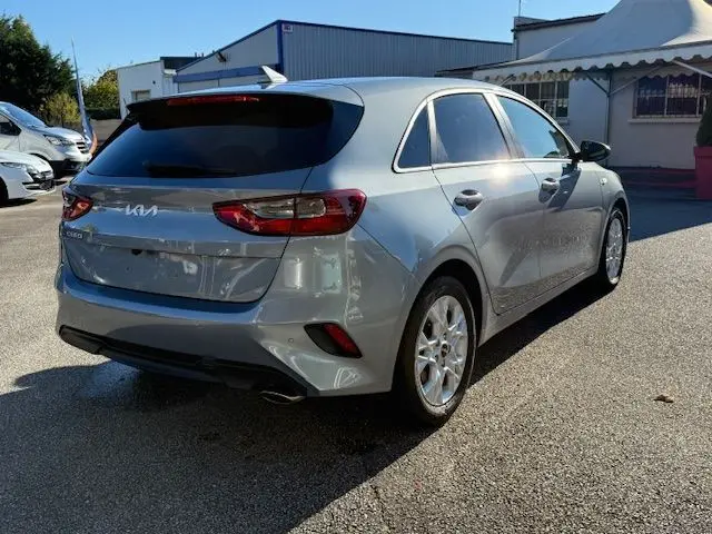 Vue 3/4 arrière droite d'une KIA CEE'D 2024 argent lunaire avec feux arrière LED et vitres teintées.