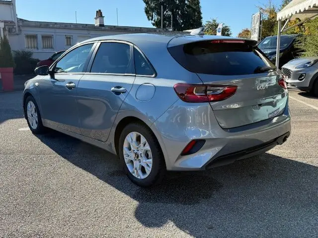 Vue 3/4 arrière droite d'une KIA CEE'D 2024 argent lunaire avec feux LED et jantes blanches en stationnement.