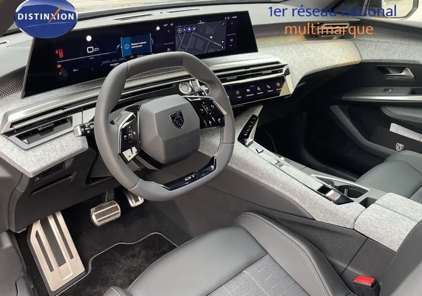 Intérieur moderne du Peugeot 5008 Hybrid 136ch GT 2025, vue côté conducteur sur le tableau de bord et volant compact noir.