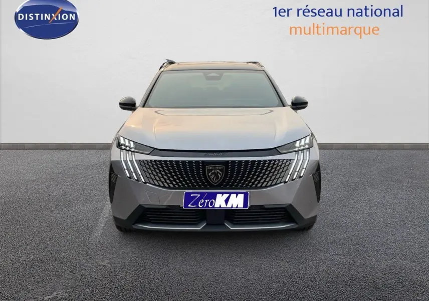 Vue frontale du Peugeot 5008 Hybrid 136ch GT gris Artense métal avec toit noir, mettant en valeur sa calandre distinctive et ses feux LED.