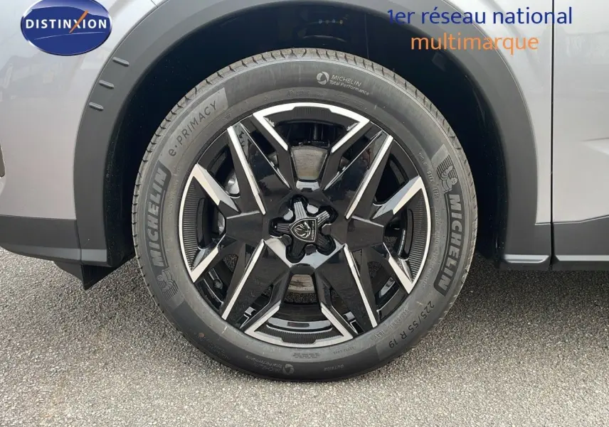 Gros plan sur la roue avant gauche du Peugeot 5008 gris Artense métal avec jante noire et argentée en 19 pouces.