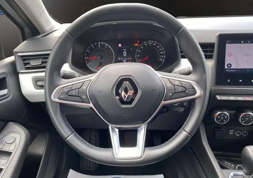 Vue frontale du volant cuir noir de la Renault Clio V TCE 90 Evolution X-Tronic avec tableau de bord et écran GPS intégré.