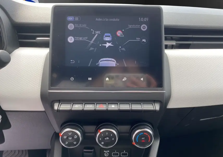 Tableau de bord de Renault Clio V TCE 90 Evolution, écran tactile affichant aides à la conduite, commandes de climatisation visibles.