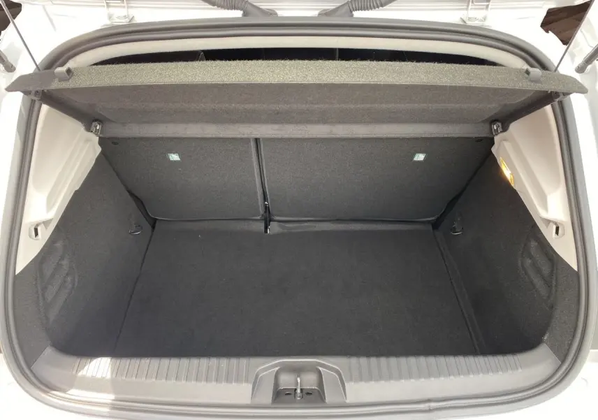 Coffre ouvert d'une Renault Clio V gris Highland, vue de dessus montrant l'espace de chargement vide et la tablette arrière.