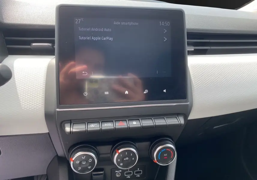 Écran tactile central affichant tutoriels Android Auto et Apple CarPlay dans l'habitacle noir de Renault Clio V 2023.