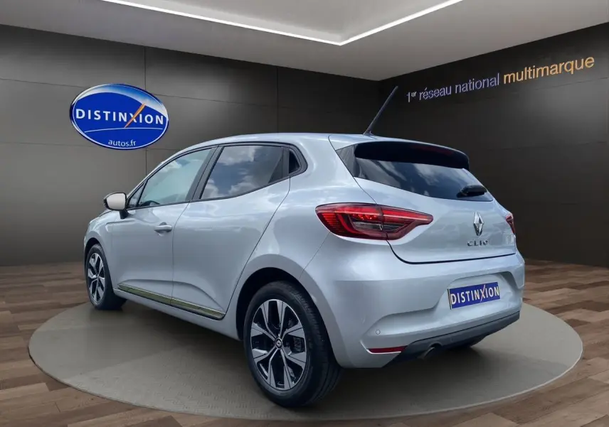 Renault Clio V TCE 90 Evolution X-Tronic gris Highland vue 3/4 arrière droit avec jantes alliage et feux LED.