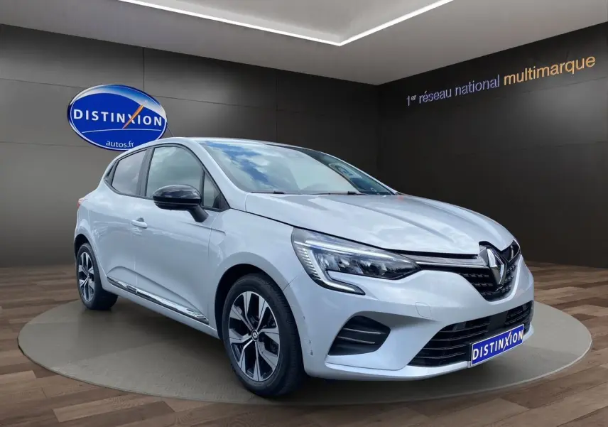 Renault Clio V TCE 90 gris Highland vue 3/4 avant droit avec jantes alliage et feux LED en showroom