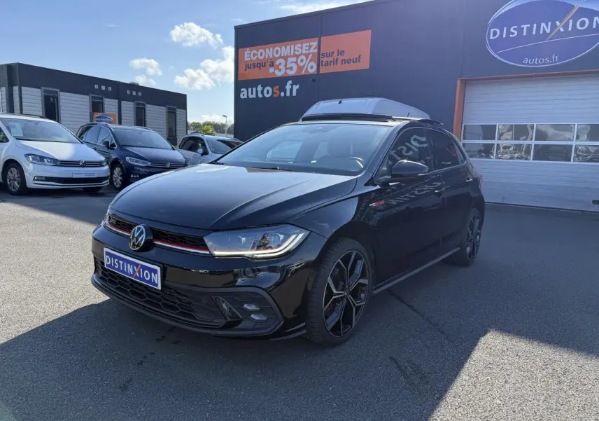 Volkswagen Polo GTI 2.0 TSI noire vue 3/4 avant droit avec jantes alliage 18 pouces et calandre GTI rouge.