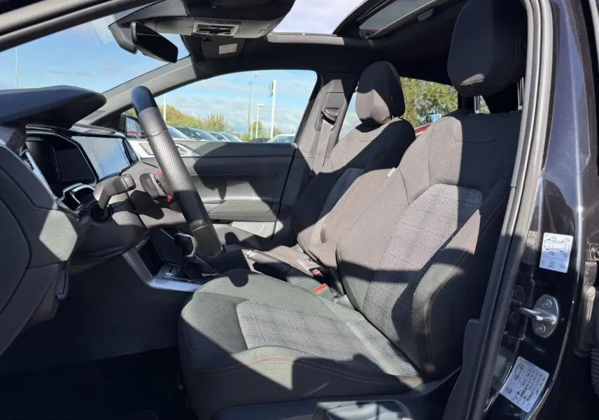 Intérieur côté gauche de la Volkswagen Polo GTI 2024 noir intense nacré, sièges sport et toit ouvrant en verre visible.