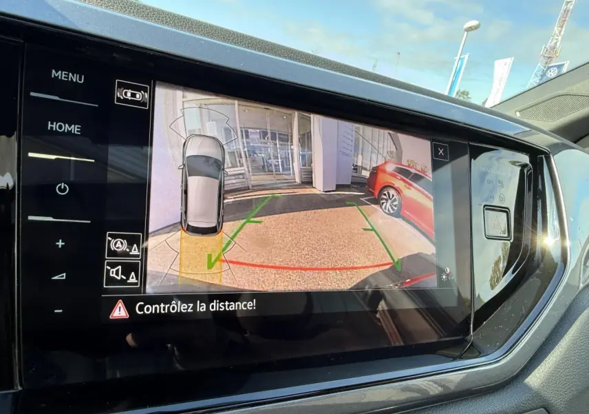 Écran tactile intérieur montrant la caméra de recul avec vue arrière et assistance au stationnement du Volkswagen Polo noir intense nacré.