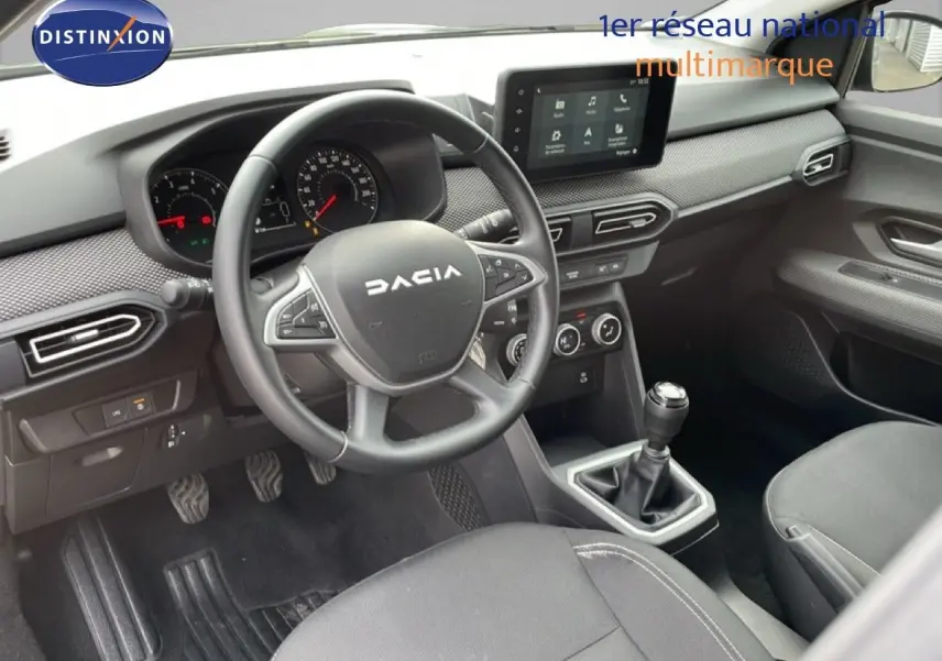 Intérieur noir du Dacia Jogger 2025 vu côté conducteur, volant multifonction et écran tactile central visible.