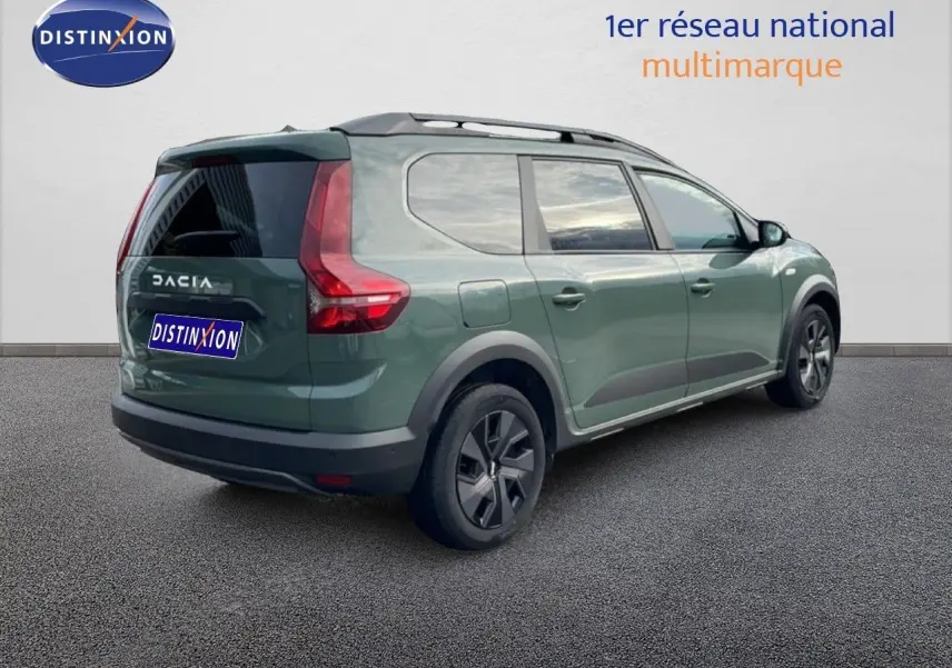 Dacia Jogger 2025 kaki lichen en 3/4 arrière droit, avec barres de toit et vitres teintées.