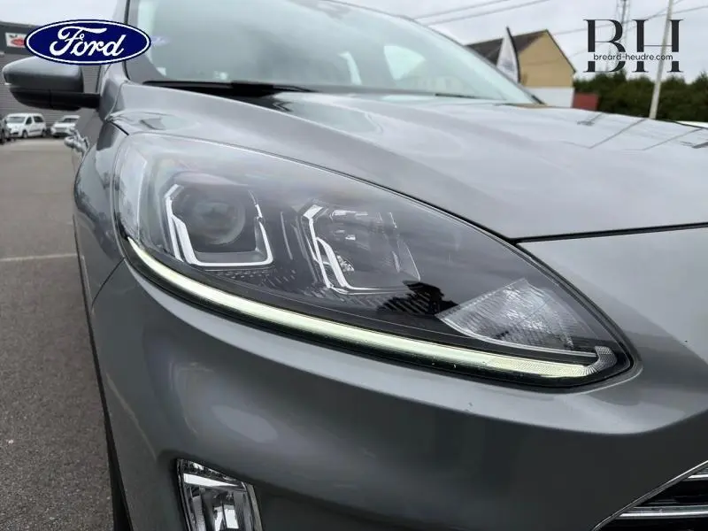 Gros plan sur le phare avant gauche du Ford Kuga 2023 gris Solar Métallisé avec éclairage LED distinctif.