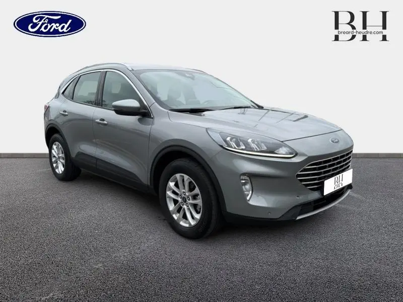 Ford Kuga gris Solar métallisé en vue 3/4 avant droit, avec calandre large et jantes alu visibles.